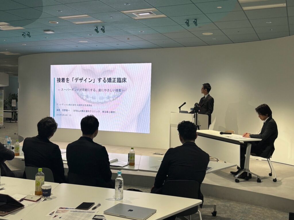 2026年9月13日に開催されたサンメディカル株式会社創立45周年記念講演会に、STELLA矯正歯科クリニック院長 吉野智一が登壇しました。「矯正臨床における歯にやさしい接着」をテーマに、装置をつけるだけでなく安全に外すところまで考えた接着について講演しました。